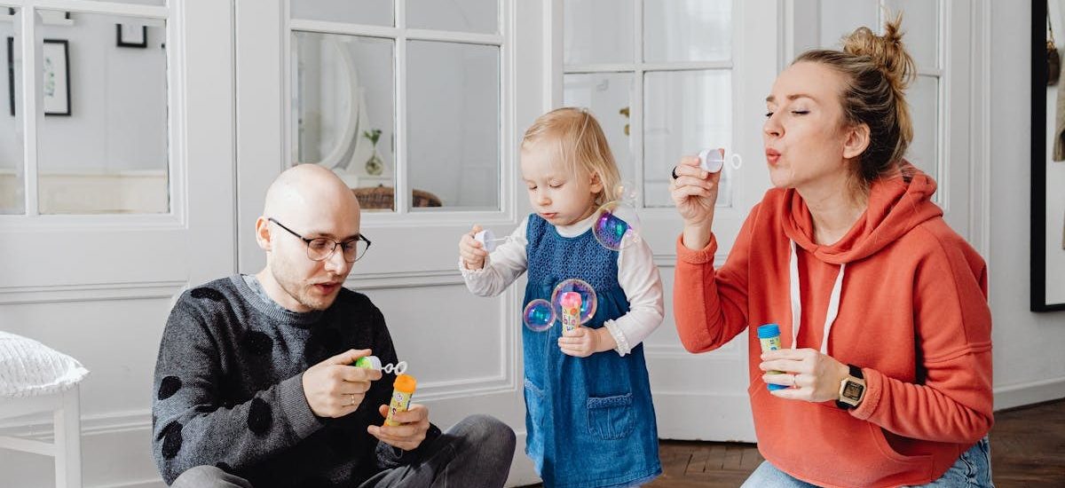 Family enjoying quality time blowing bubbles indoors, capturing joyful moments.